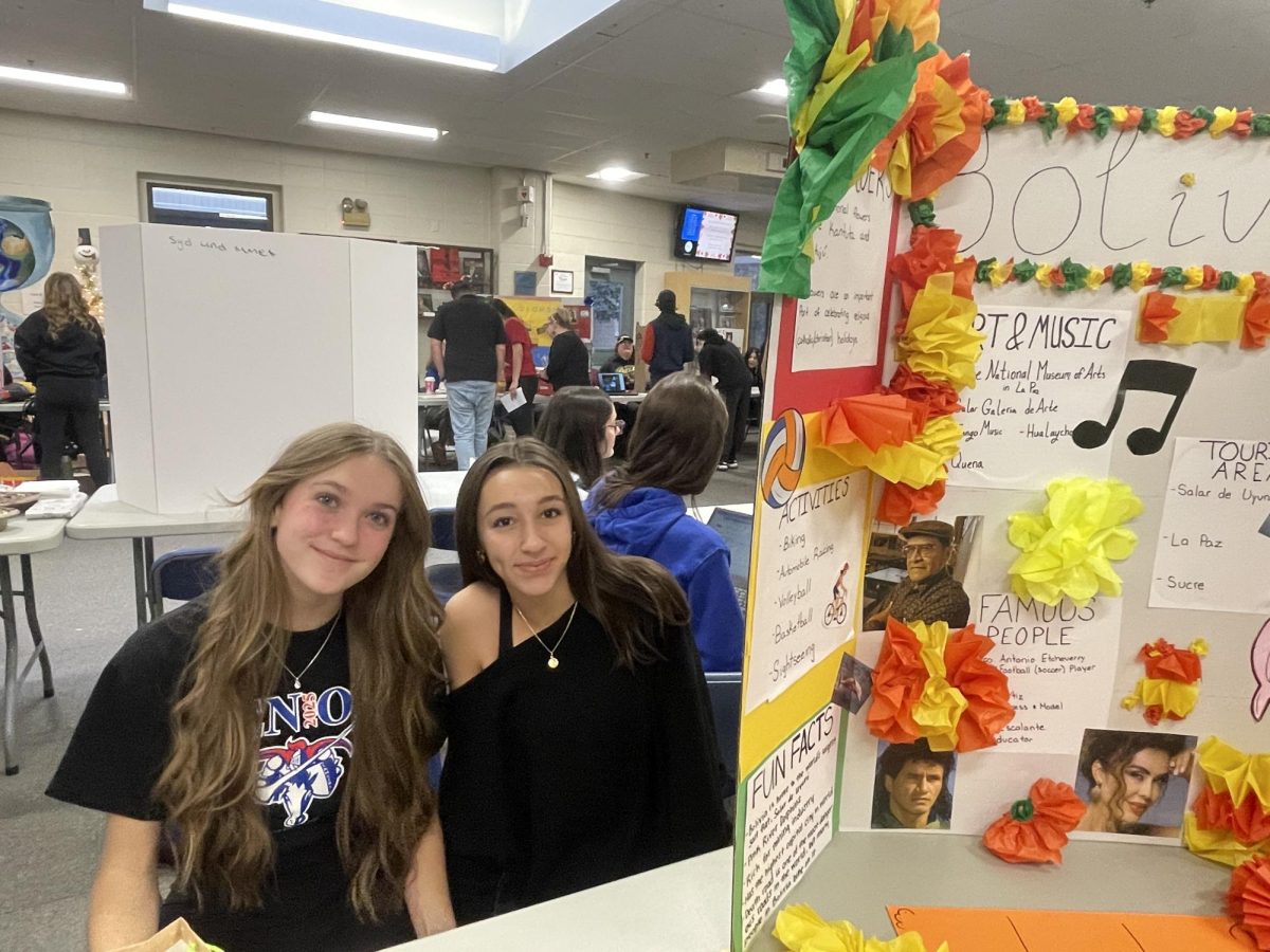 Seniors Ali Von Pichl and Ava Windisch display their projects in the foyer teaching others about the country they had researched. 