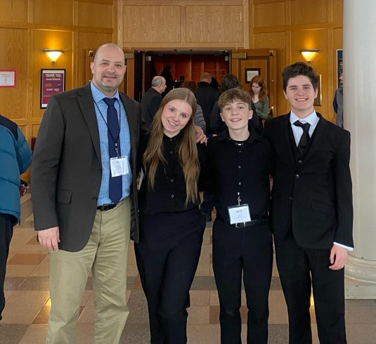 Music director with senior James Dooley, juniors Kelsey Sweet and Jacob Sevigny at the venue for the Jazz All-State concerts. Photo provided by James Dooley