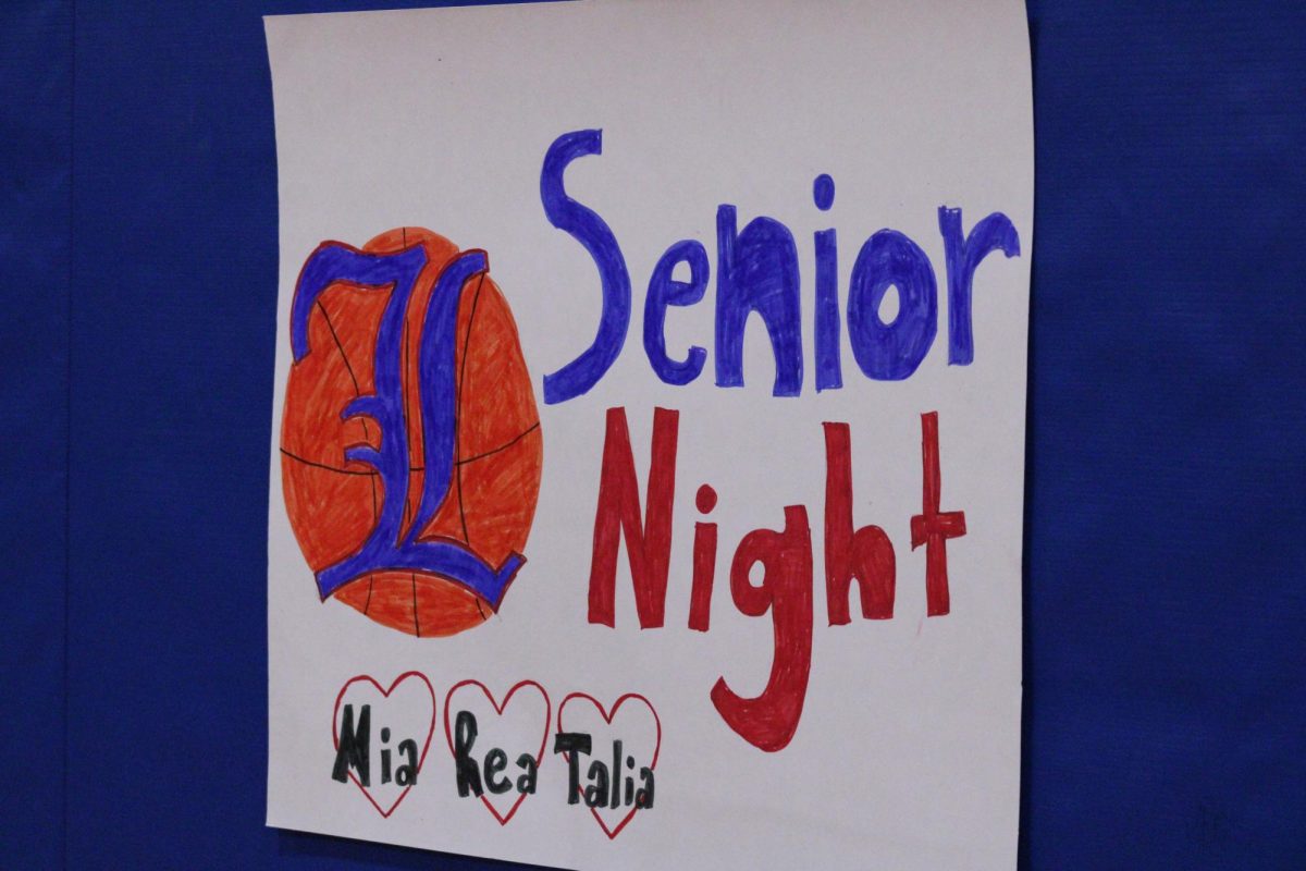 Signs line the end of the court, highlighting the senior athletes.