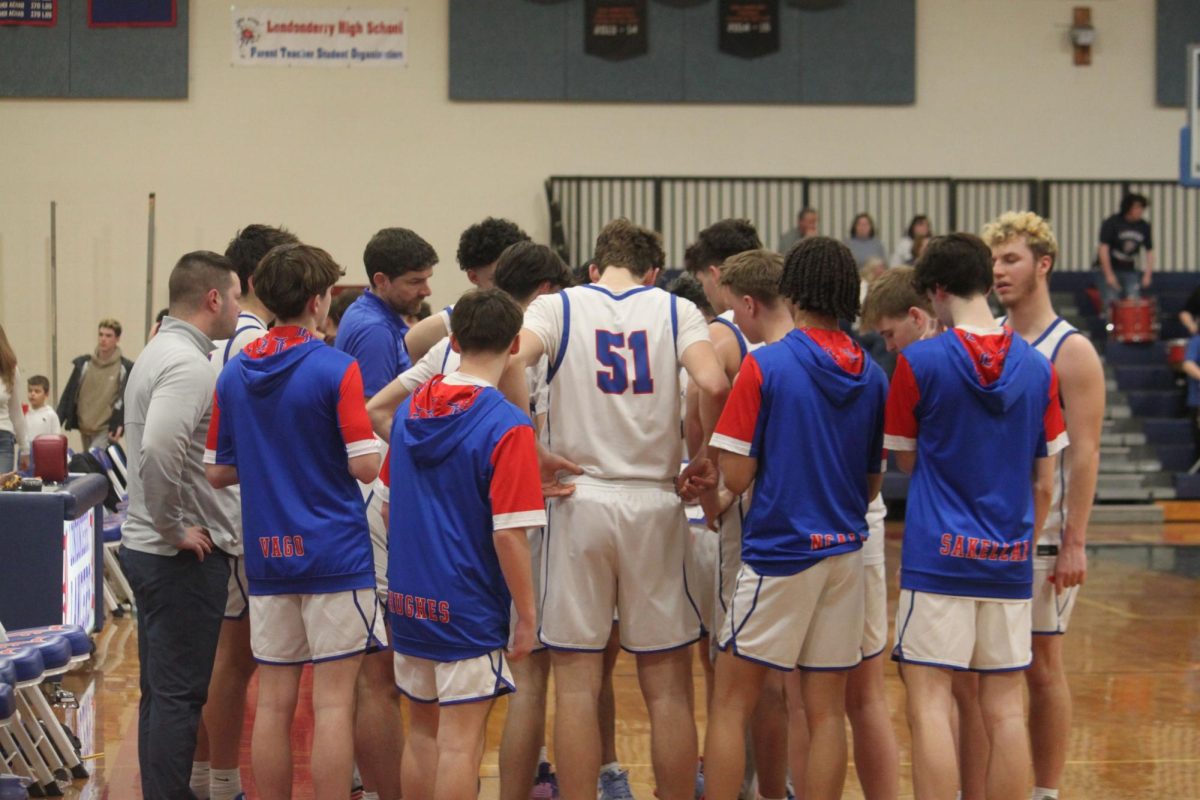 The boys varsity basketball team, huddles in preparation for their last regular season home game.